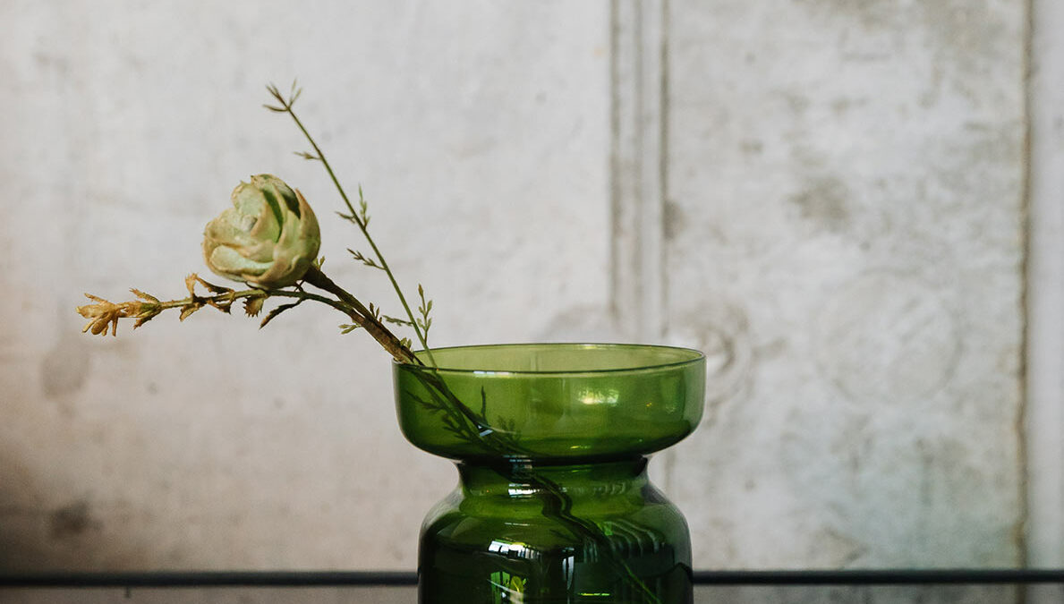 green glass candle holder shown as a vase