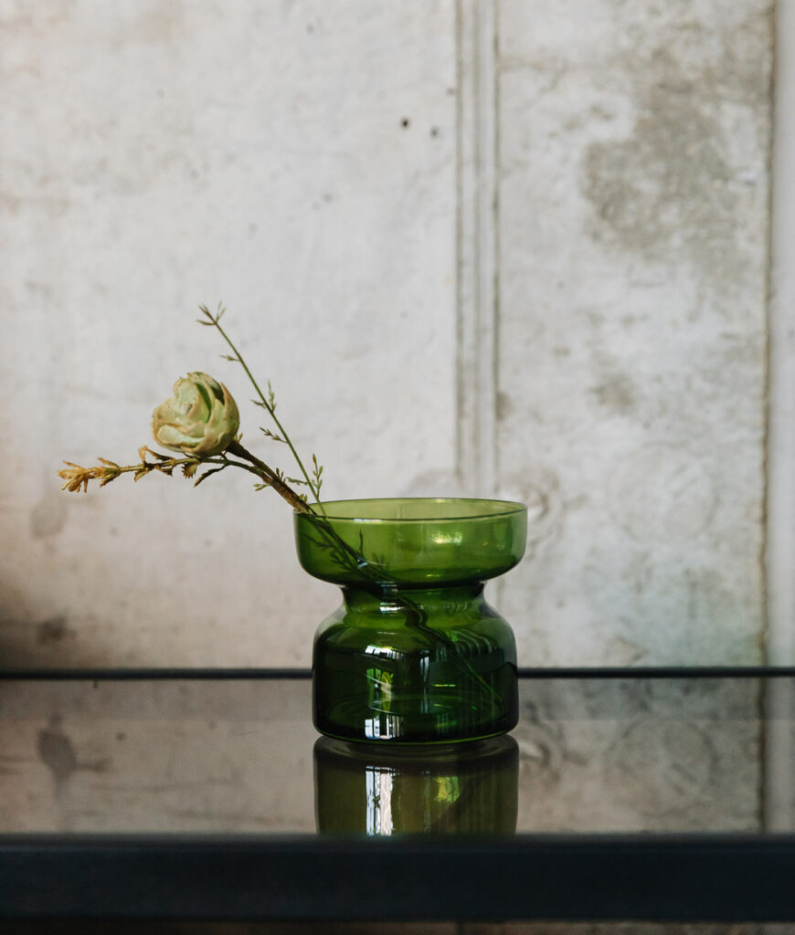 green glass candle holder shown as a vase