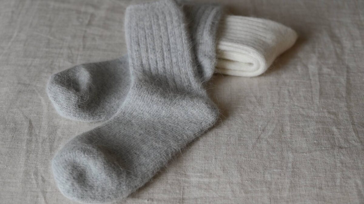 2 pairs of Angora blend socks with rib top. Ivory pair neatly folded, grey pair laid flat on top.