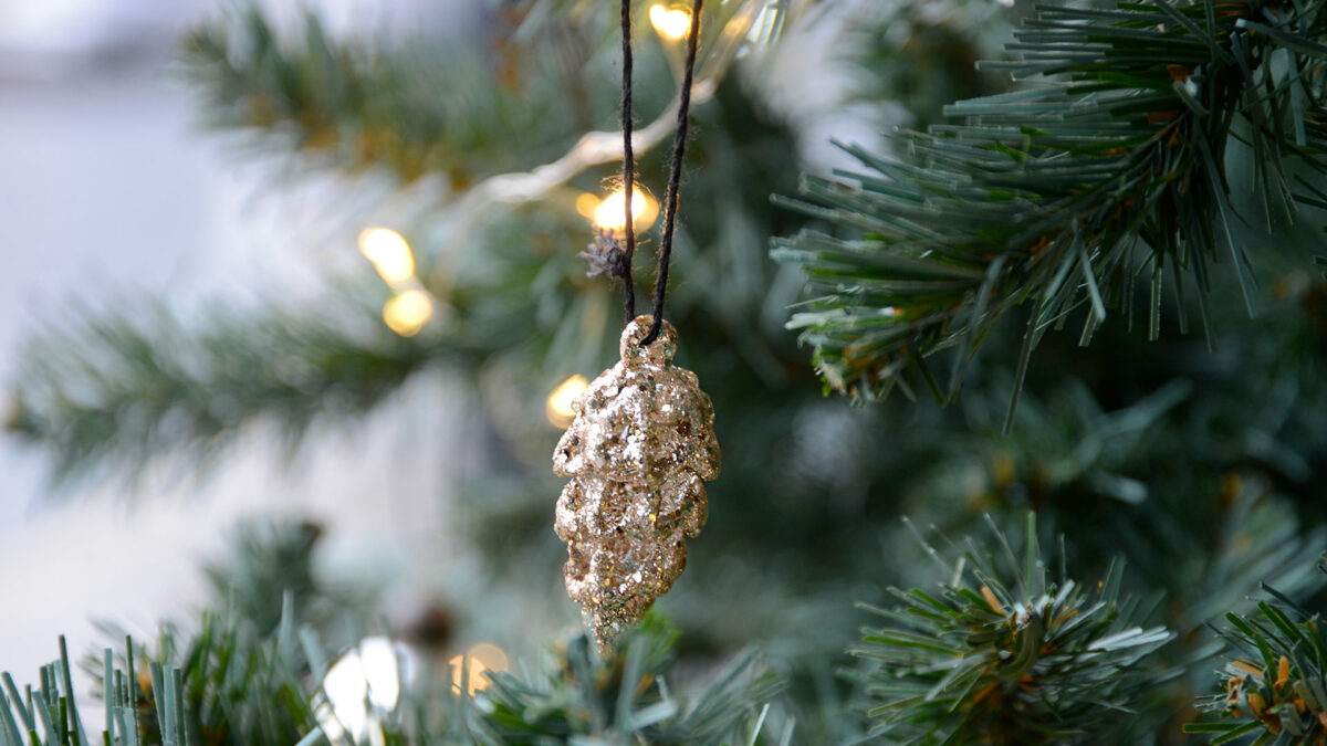 gold glitter Pine cone Xmas decoration shown on a tree