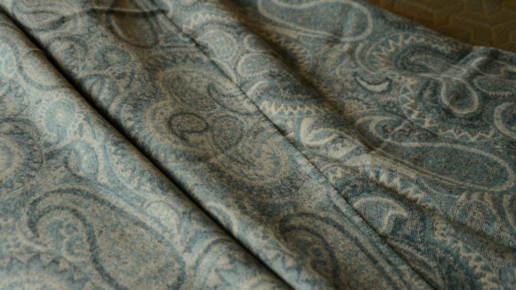 Paisley patterned merino wool throw in muted aqua tones