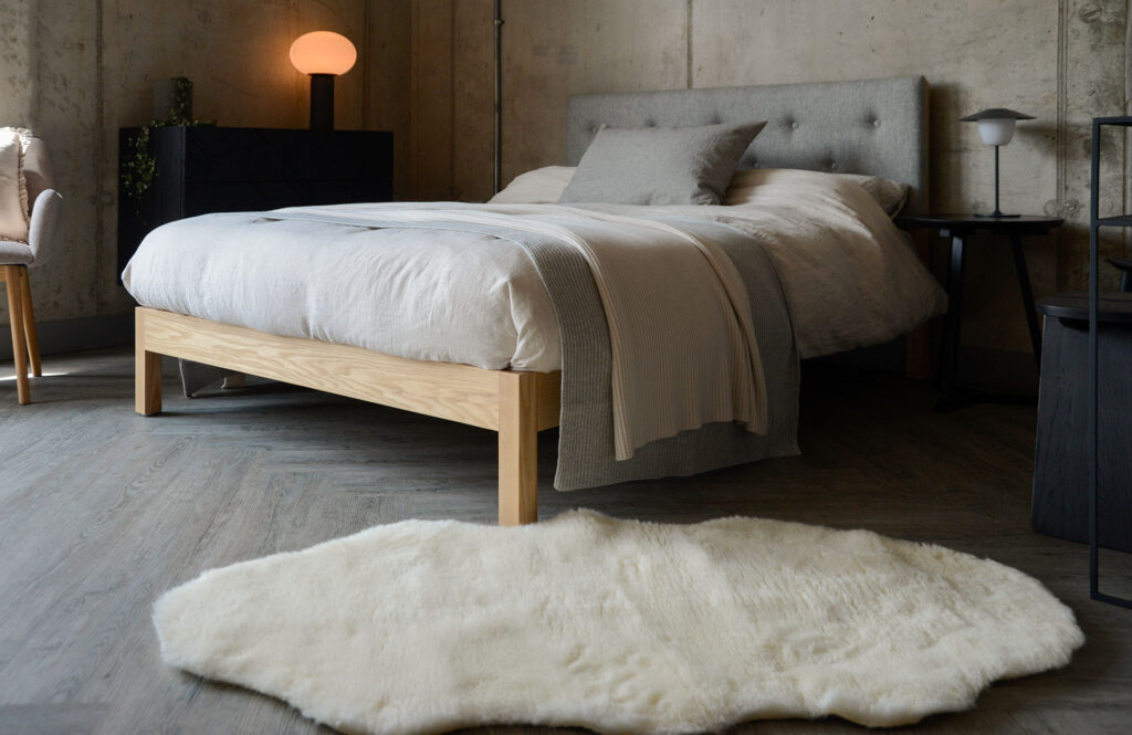 ash Arran bed with grey headboard and faux sheepskin rug 1250