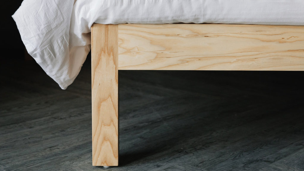 A close up of the chunky leg of the Bamford hand made wooden bed in solid Ash wood