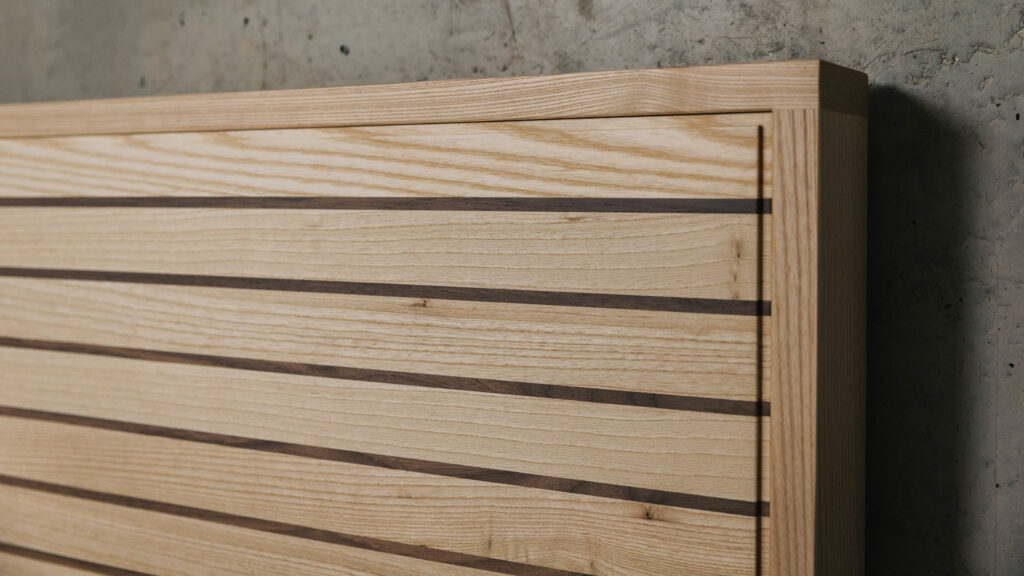 A special edition Leith bed in Ash wood with walnut stripes to the headboard panel a close up view