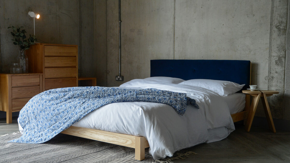 ash iona with blue velvet headboard and white and blue bedding