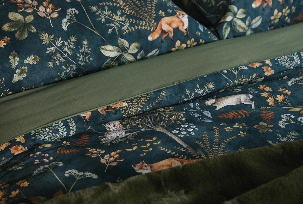 Dark green duvet cover and pillowcase set with a nature print of foxes, plants, and owls