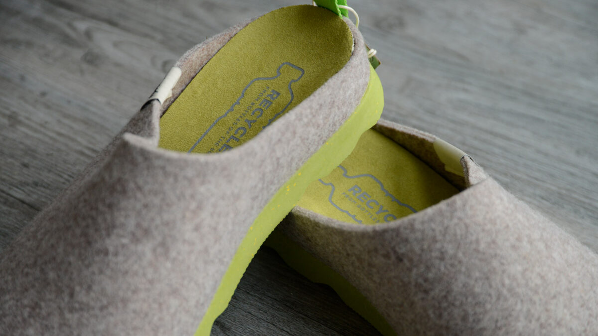 beige felt look slippers with chunky lime green soles sustainably made from recycled bottles