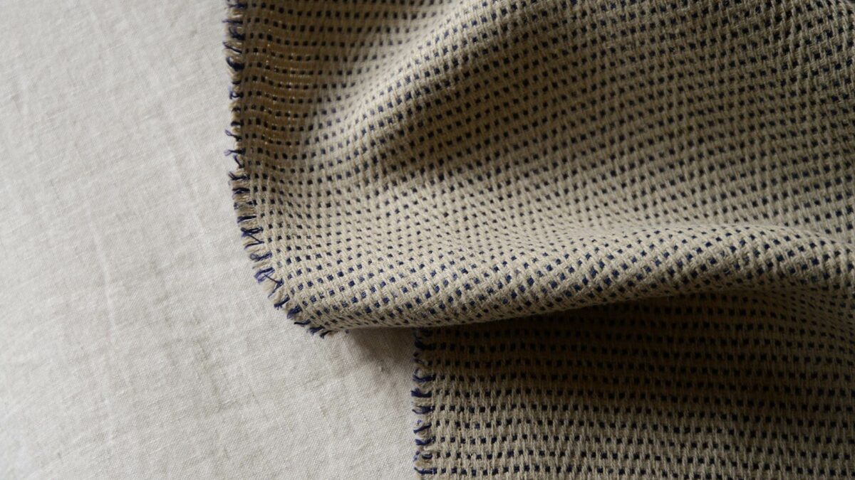 textured herringbone weave linen blanket in sand and purple shown close up