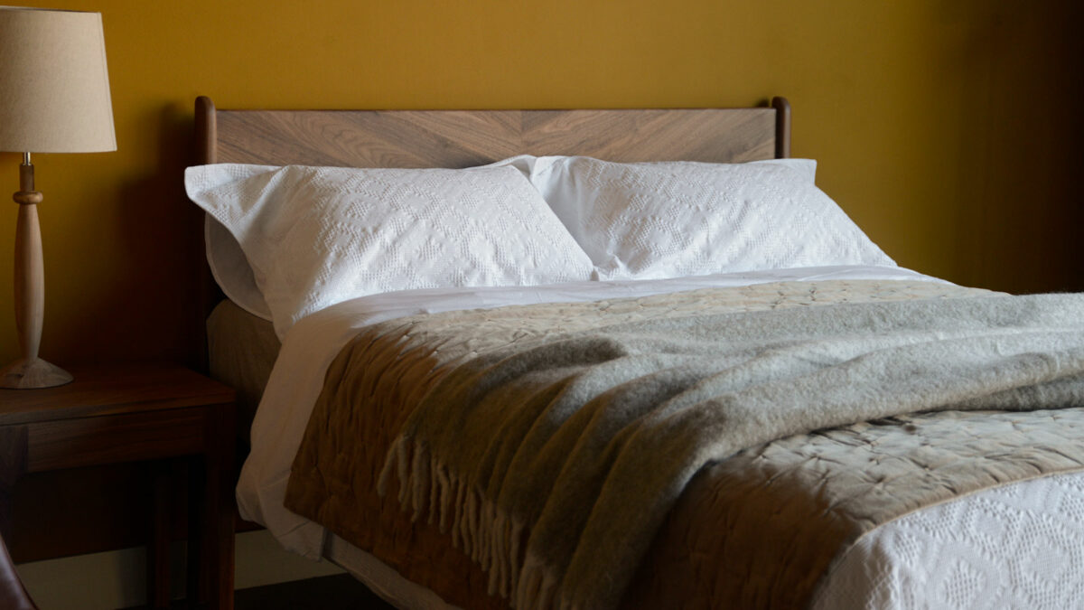 pale brown softly quilted reversible velvet bedspread shown on a kingsize wooden bed