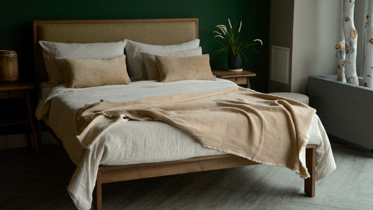 organic cotton reversible throw in beige and ivory shown on a kingsize bed