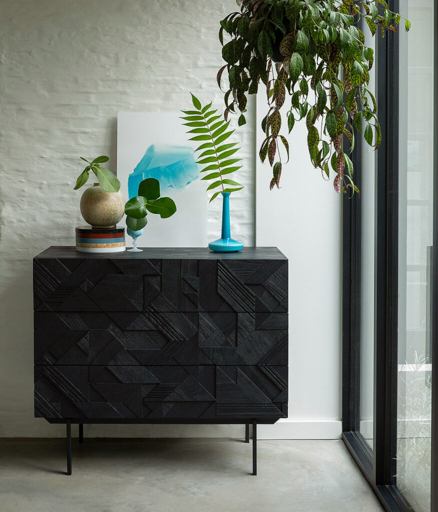 black teak chest of drawers with a carved graphic pattern