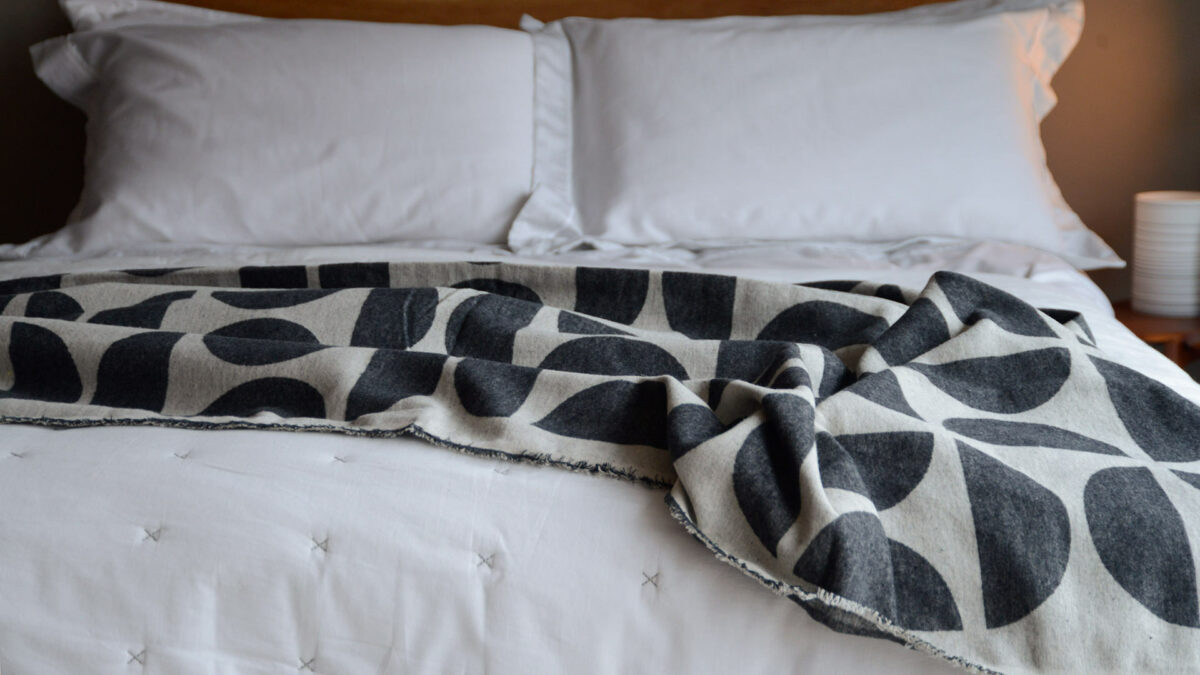 graphic patterned soft cotton throws in black and ecru shown on a bed