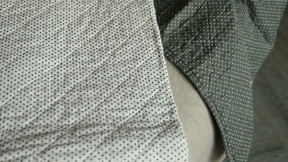 black and white dot print quilt with olive grey throw
