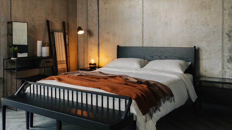 Industrial style bedroom with Black oak furniture including a Camden bed and spindle bench