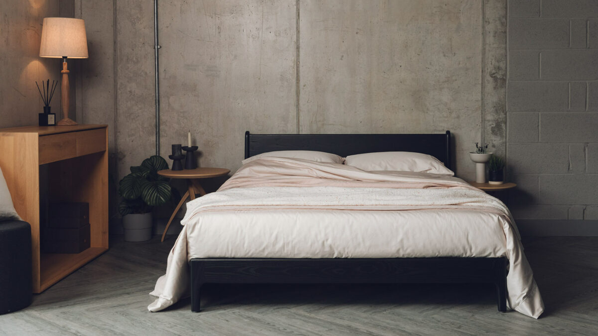 low mid century style Pimlico bed in black painted Ash wood shown with blush pink bedding