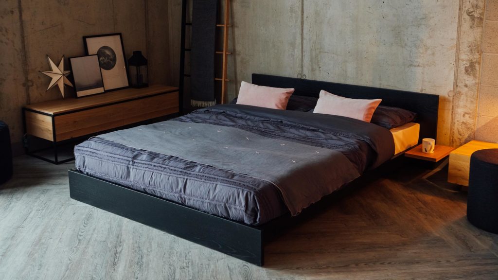 Cosy industrial look bedroom with black painted Oak low Kulu bed.