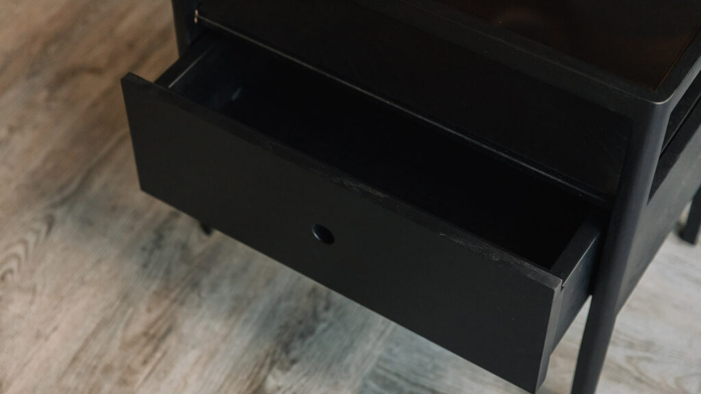 Spindle bedside table in black showing the drawer open