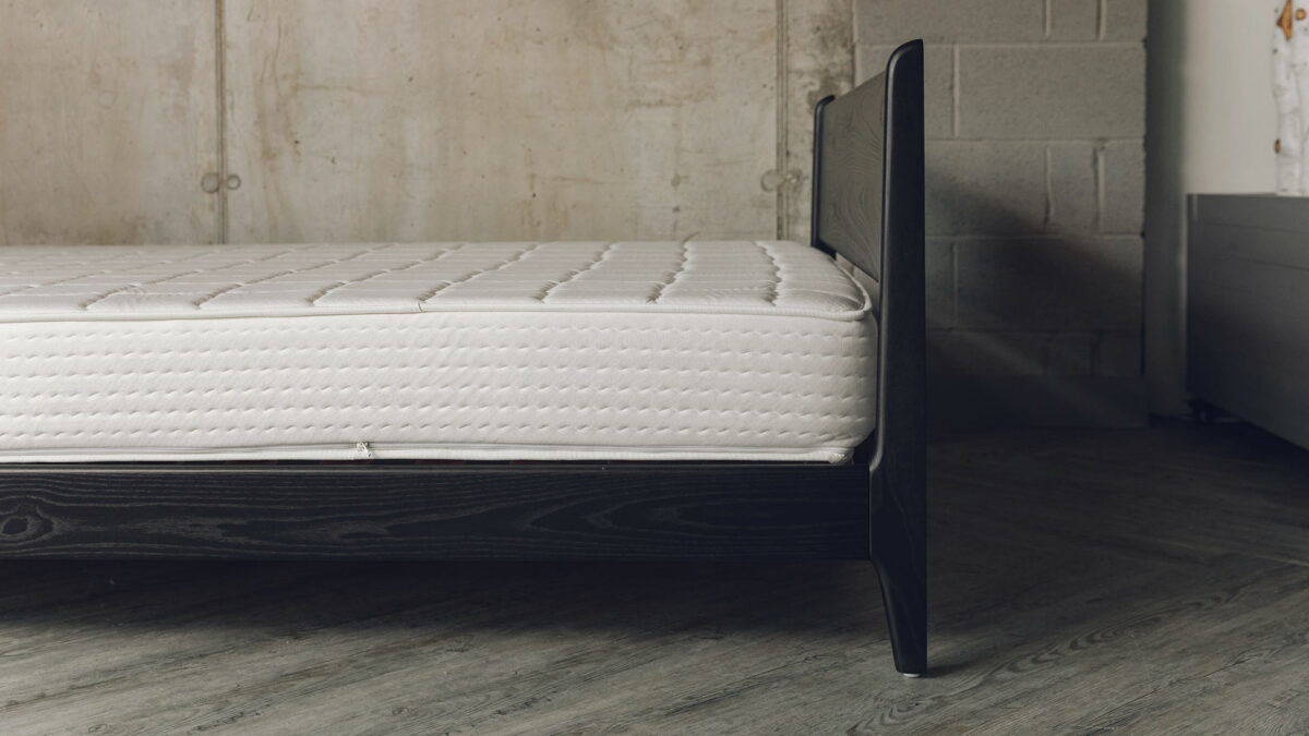 The Pimlico low bed here is made from black stained solid Ash wood and is shown from the side and without bedding