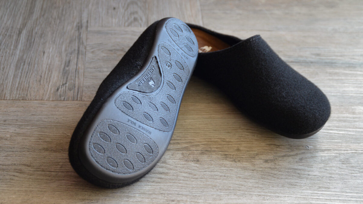 pair of men's black slippers., rubber sole visible on one.