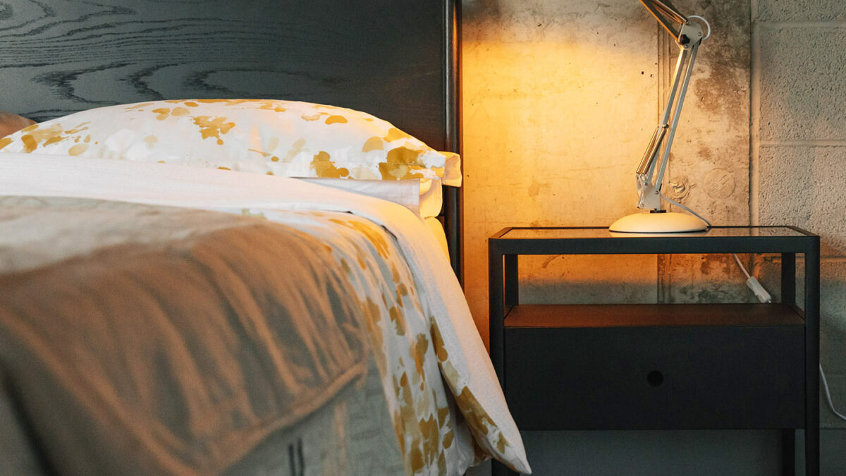 black spindel bedside with ochre ink flower bedding