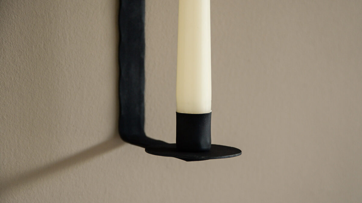 black wall mounted candle stick holder base close up