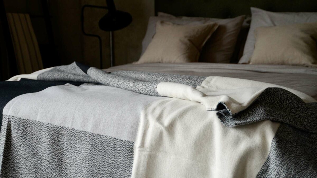 soft touch cotton monochrome block weave design throw or blanket shown on a bed