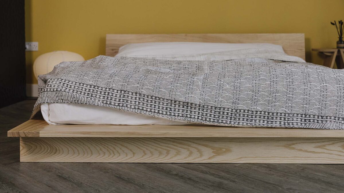 Grey Block print bedspread with wave design spread over the Oregon bed frame.