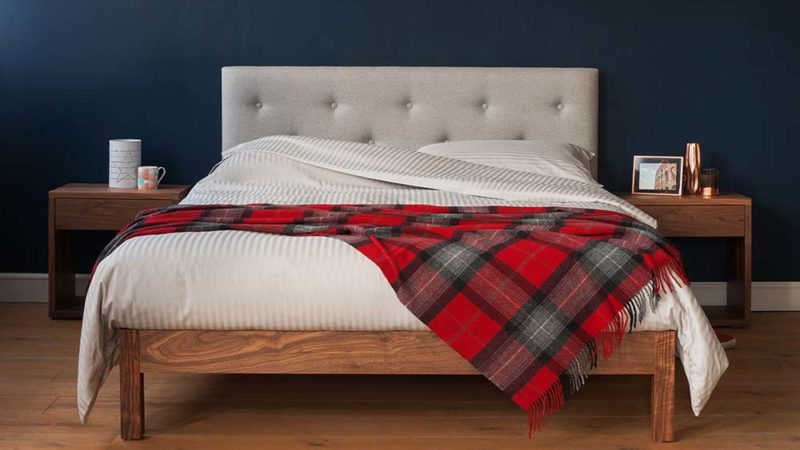 Woollen red-checked throw gives the Arran bed with grey upholstered headboard a seasonal look