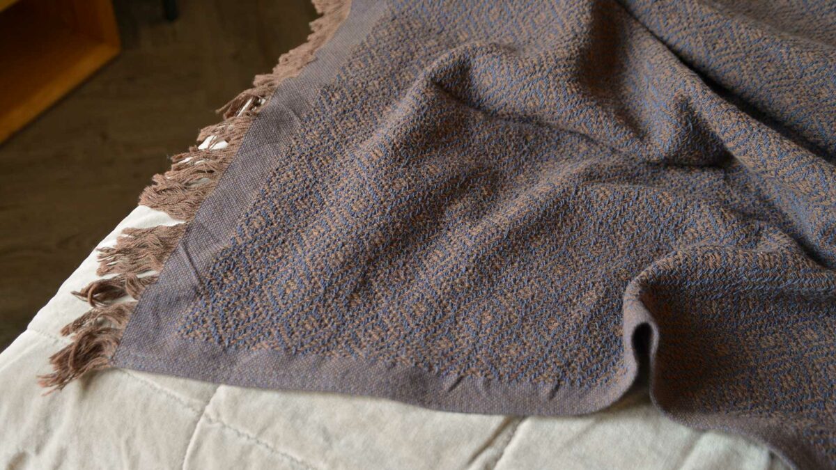 cotton rich woven diamond pattern throw in russet brown and blue