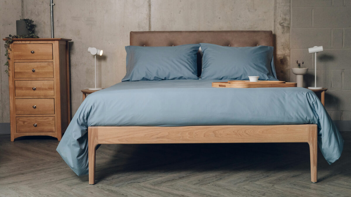 oiled oak Bloomsbury bed with faux leather upholstered headboard and dressed with storm blue cotton bedding