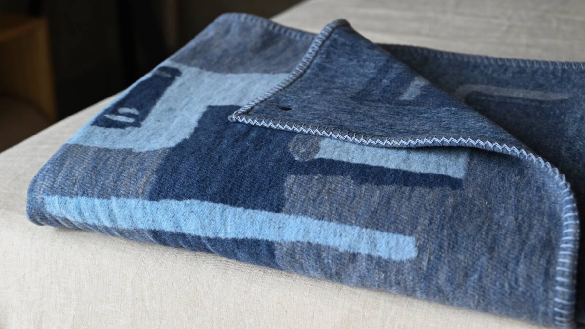 Neatly folded throw with abstract pattern in shades of blue.
