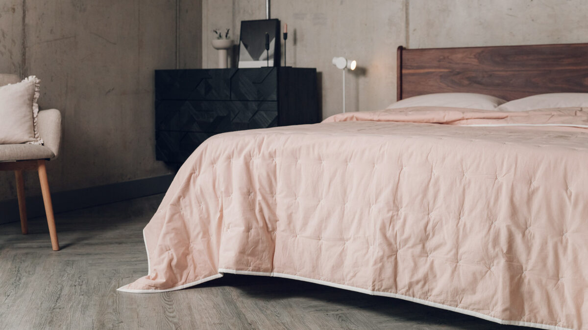 blush pink quilted cotton bedspread shown on a kingsize bed