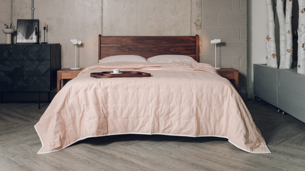 blush pink quilted cotton bedspread shown on a kingsize solid walnut Camden bed