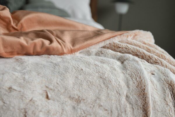 Frosted pink faux fur throw a view showing the reverse salmon pink velveteen fabric