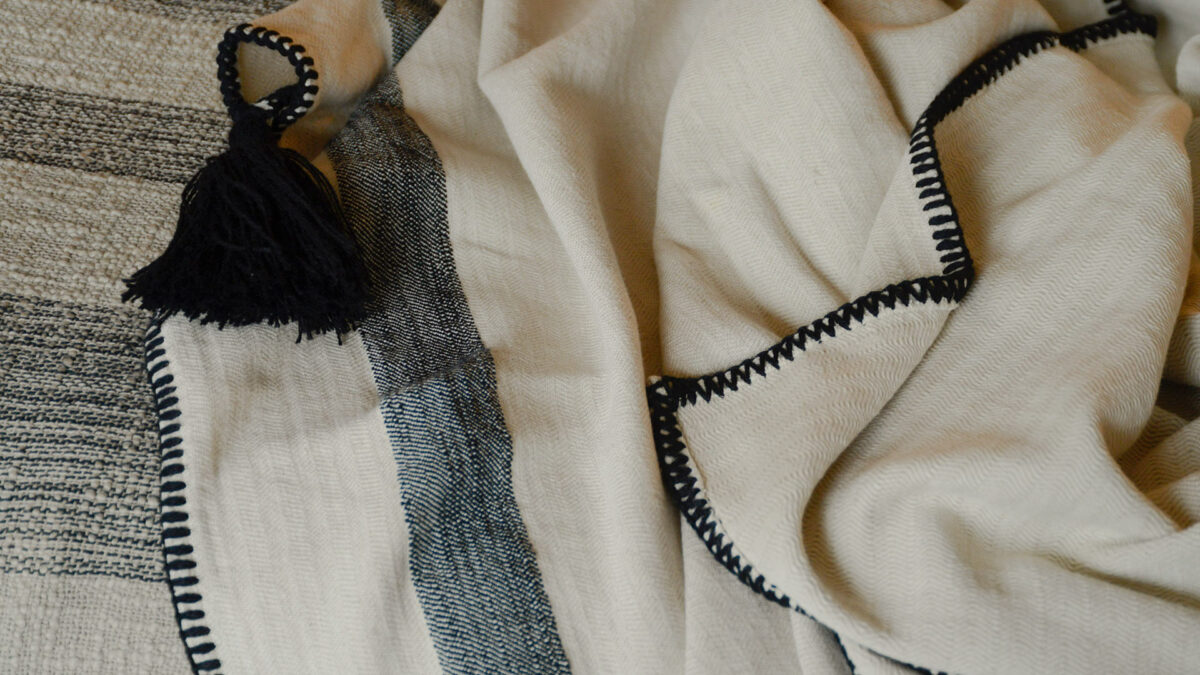 woven cotton throw in ivory and black with black tassel and stitched edge