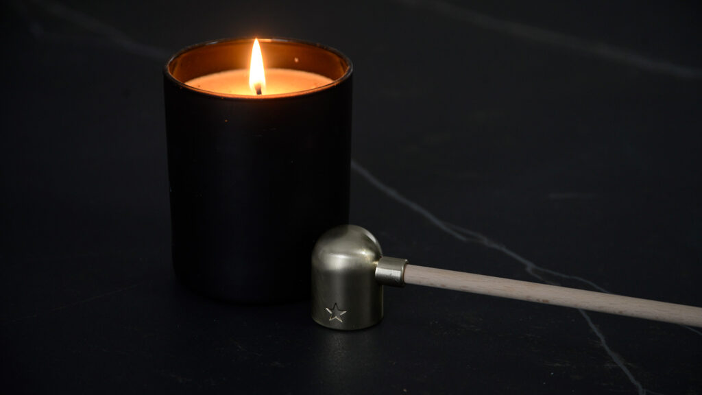 brass colour candle snuffer with wooden handle