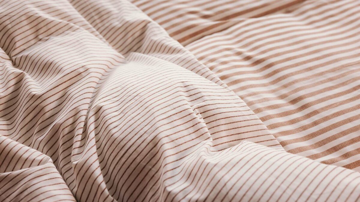 brick and ivory striped bedding detail