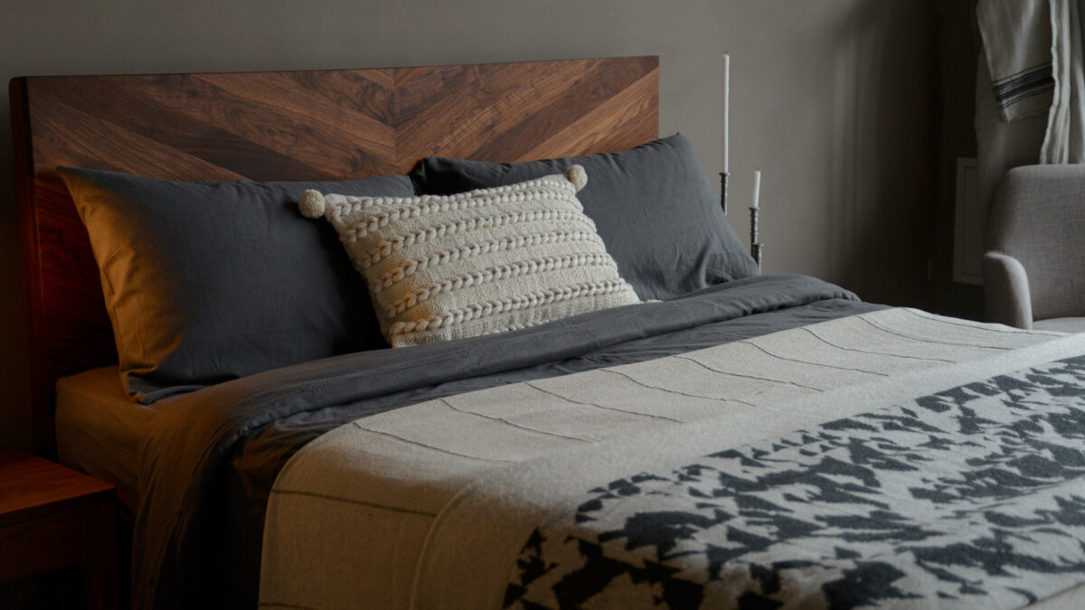 soft brushed cotton bedding in slate grey shown with stone coloured throws and on a walnut Hathersage bed