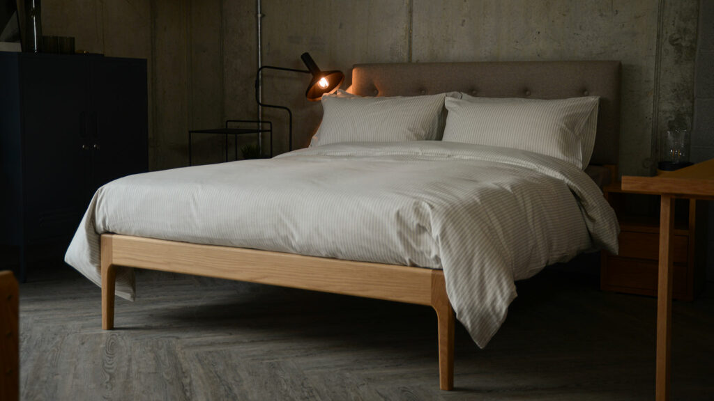 Nordic style bedroom with neutral colours and a wooden Bloomsbury bed with upholstered headboard