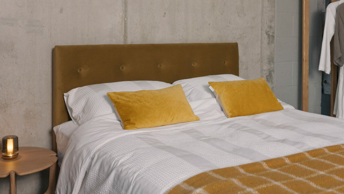 buttoned eco velvet headboard and white striped bedding