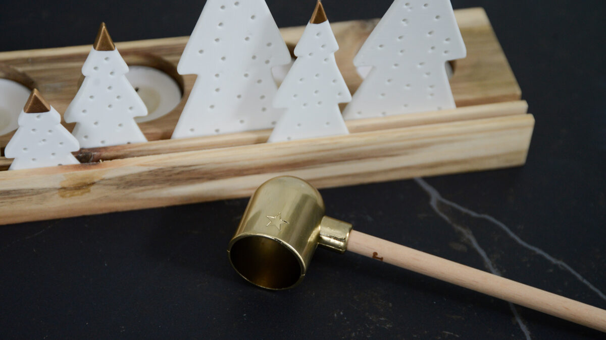 modern brass candle snuffer with a wooden handle