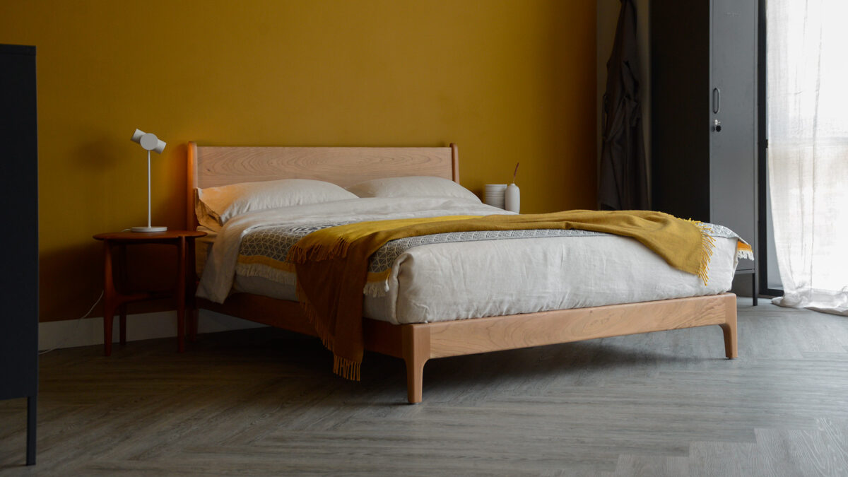 Our low mid century style Carnaby bed made from cherry wood in an ochre toned bedroom