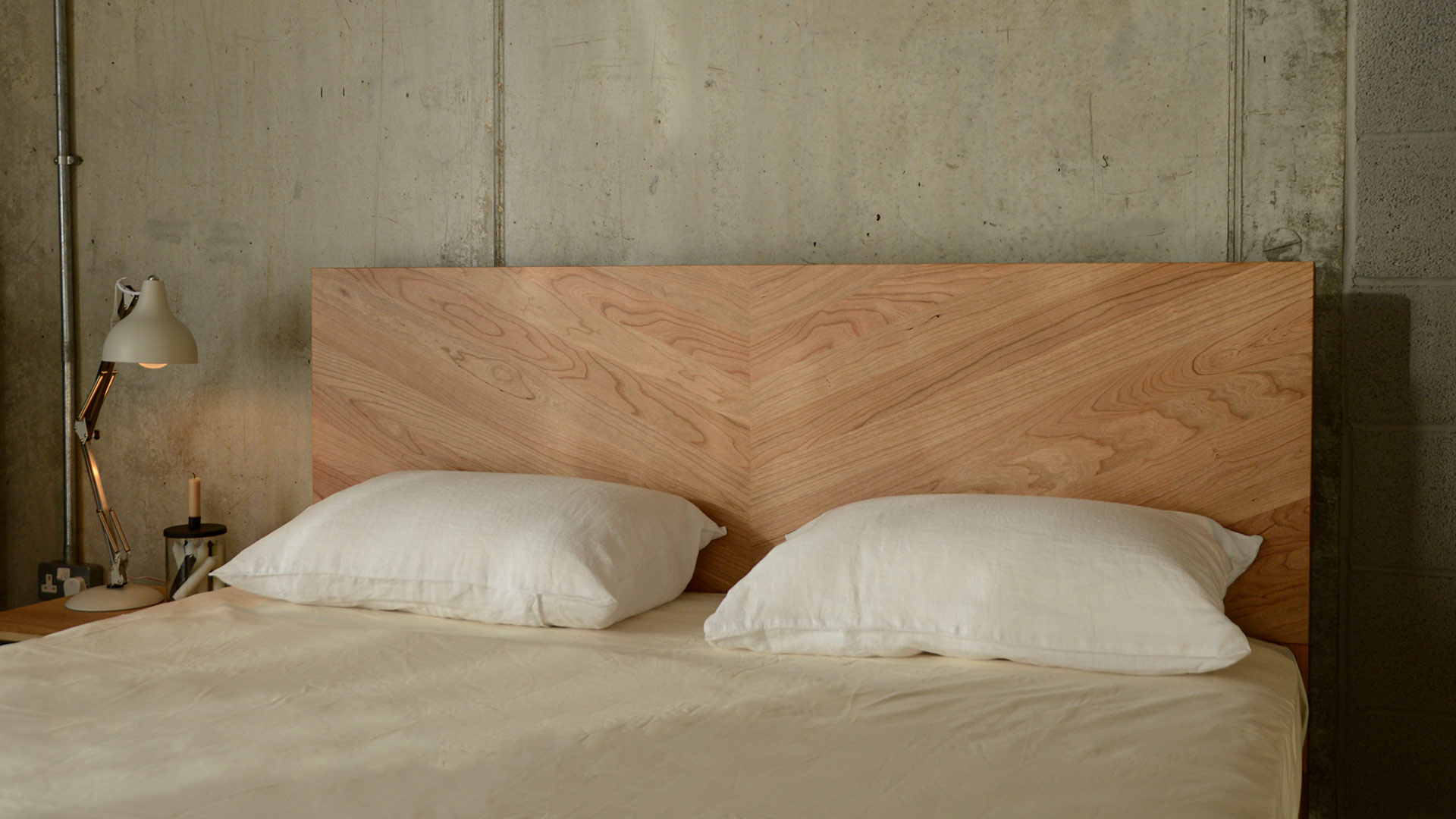 the parquet patterned headboard of our Hathersage solid wooden bed in cherry