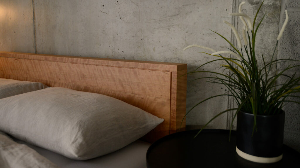 Leith bed headboard in solid cherry wood with a rippled grain