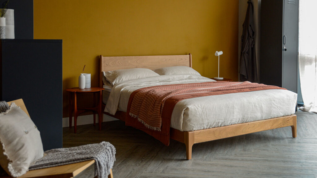 Carnaby low bed in cherry timber with terracotta bedding and ethnicraft pi side table.