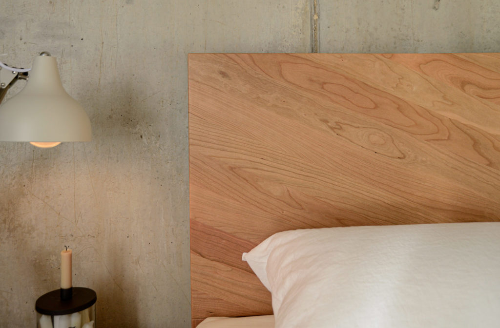 Detail view of the parquet pattern wooden headboard of the cherry Hathersage bed