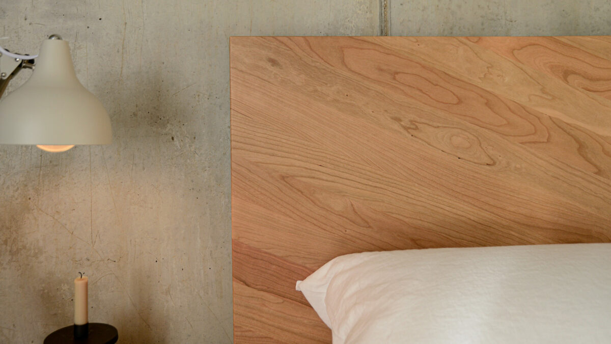 Detail view of the parquet pattern wooden headboard of the cherry Hathersage bed