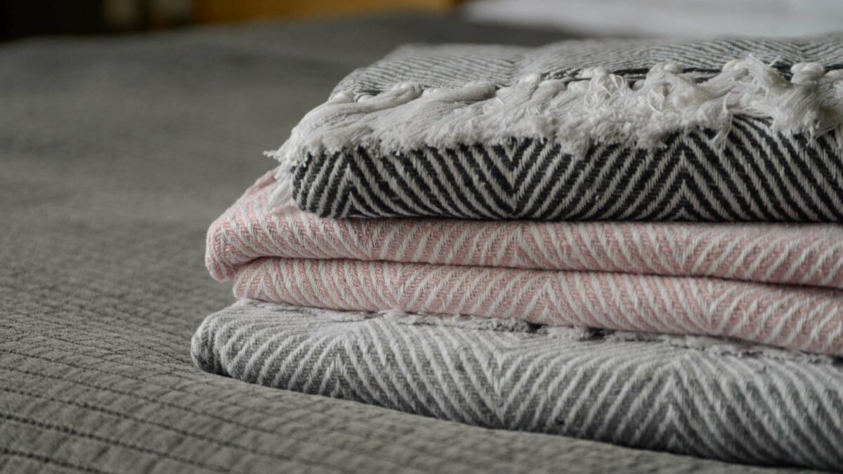 a stack of summer cotton look throws made with recycled fibres