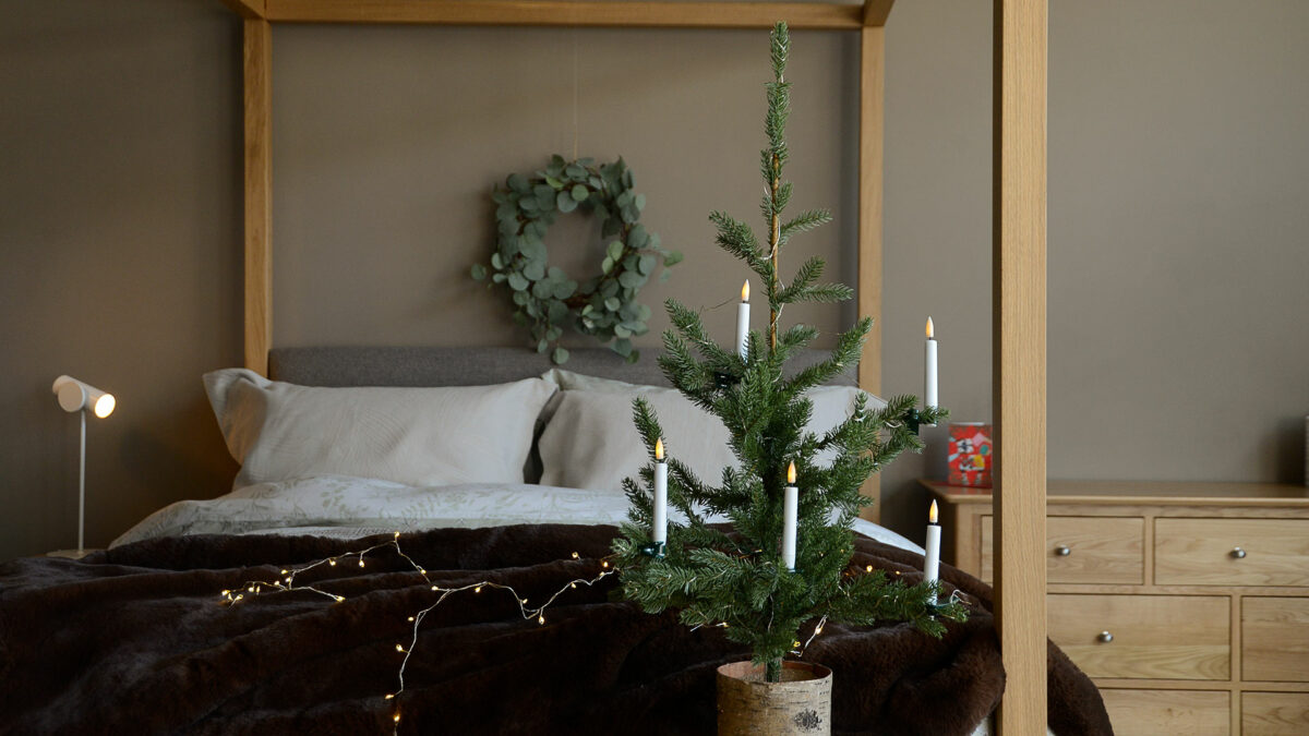 Christmas bedroom with LED string lights and Highland 4-poster bed in oak