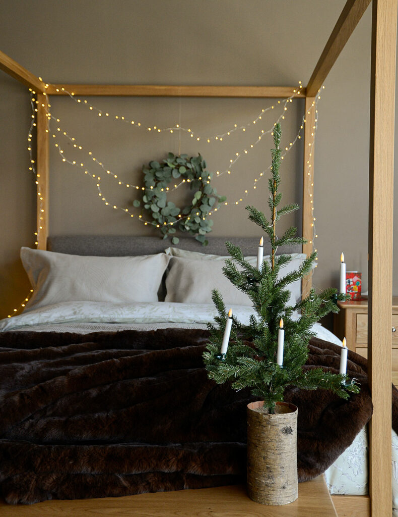 christmas bedroom with LED string lights and Highland 4-poster bed in oak